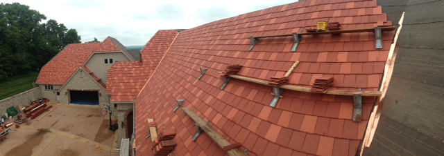 Roof with red tiles and wooden scaffolding for repairs.